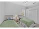 Comfortable bedroom featuring two twin beds, a window with blinds, ceiling fan, and closet at 8979 Grey Oaks Ave, Sarasota, FL 34238