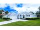 Charming single-story home with manicured lawn and lush landscaping creating excellent curb appeal at 8979 Grey Oaks Ave, Sarasota, FL 34238