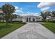 Well-manicured front yard with a patterned driveway and lush landscaping at 8979 Grey Oaks Ave, Sarasota, FL 34238