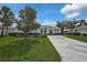Beautifully landscaped front yard with mature tree and a well-kept lawn at 8979 Grey Oaks Ave, Sarasota, FL 34238