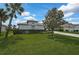 Grassy front yard featuring a manicured hedge and large tree at 8979 Grey Oaks Ave, Sarasota, FL 34238
