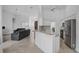 Open concept kitchen with granite countertops, white cabinets, and stainless steel appliances at 8979 Grey Oaks Ave, Sarasota, FL 34238