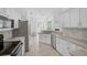 Open kitchen layout with white cabinets, stainless appliances, and breakfast bar at 8979 Grey Oaks Ave, Sarasota, FL 34238