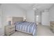 Well-lit main bedroom featuring a large bed, dresser, end tables, and overhead ceiling fan at 8979 Grey Oaks Ave, Sarasota, FL 34238