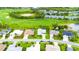 Aerial view of a residential street showcasing well-manicured lawns and a serene golf course and pond nearby at 8979 Grey Oaks Ave, Sarasota, FL 34238