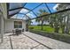The covered screened patio overlooks the golf course and features a table for outdoor dining at 8979 Grey Oaks Ave, Sarasota, FL 34238