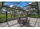 This covered, screened patio is perfect for outdoor enjoyment, overlooking the lush landscaping at 8979 Grey Oaks Ave, Sarasota, FL 34238