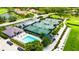 Aerial view of community tennis courts and pool area, offering residents recreational opportunities and social spaces at 8979 Grey Oaks Ave, Sarasota, FL 34238