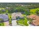 Expansive aerial view of a home with manicured lawns, mature trees, and a serene lake nearby at 9016 30Th E St, Parrish, FL 34219