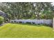 Large, fenced backyard featuring green grass and mature trees for privacy at 9016 30Th E St, Parrish, FL 34219