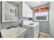 Spacious laundry room with a sink, white cabinets, and modern washer and dryer at 9016 30Th E St, Parrish, FL 34219