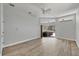 Bright living room boasts wood floors, ceiling fan, and sliding glass doors leading to the screened outdoor space at 9016 30Th E St, Parrish, FL 34219