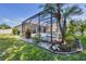 Enclosed pool with beautiful landscaping and lush green grass on a sunny day at 9016 30Th E St, Parrish, FL 34219