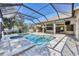 Screened-in pool area with a spa, pool, and outdoor kitchen with seating, perfect for entertaining at 9016 30Th E St, Parrish, FL 34219