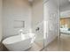 Bright bathroom boasts a soaking tub, textured wall, and access to the main bedroom at 100 6Th S St, Bradenton Beach, FL 34217