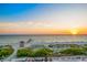 Beautiful beach view featuring a lifeguard tower and pier against a backdrop of a colorful sunset over the water at 100 6Th S St, Bradenton Beach, FL 34217
