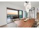 Elegant dining room featuring a large table and modern chandelier, with a stunning ocean view through expansive glass doors at 100 6Th S St, Bradenton Beach, FL 34217