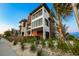 Modern two-story home featuring a unique facade, large windows, and beautiful landscaping at 100 6Th S St, Bradenton Beach, FL 34217
