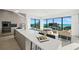 Open-concept kitchen and living room with sleek cabinetry, modern appliances, and ocean views at 100 6Th S St, Bradenton Beach, FL 34217