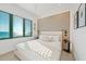 Beautiful bedroom boasts ocean views with a modern geometric accent wall and stylish bedside tables at 100 6Th S St, Bradenton Beach, FL 34217