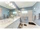 This bathroom has a double vanity, a tiled shower, and a blue accent wall for a spa-like feel at 1219 Thornbury Dr, Parrish, FL 34219