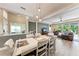 Formal dining room with a farmhouse-style table and a view of the entryway, living area, and outdoor pool at 1219 Thornbury Dr, Parrish, FL 34219