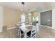 Formal dining room with a farmhouse-style table and a view of the entryway, living area, and kitchen at 1219 Thornbury Dr, Parrish, FL 34219