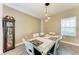 Formal dining room with a farmhouse-style table, chandelier, and an antique grandfather clock for a unique touch at 1219 Thornbury Dr, Parrish, FL 34219