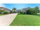Well-manicured front yard with lush green lawn, tropical landscaping, and a view of the charming home at 1219 Thornbury Dr, Parrish, FL 34219