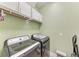 Well-organized laundry room featuring modern washer and dryer, storage cabinets, and wire shelving at 1219 Thornbury Dr, Parrish, FL 34219