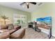 Relaxing living room features a ceiling fan, a TV, and a soft leather armchair with an ottoman at 1219 Thornbury Dr, Parrish, FL 34219