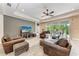 Spacious living room with wood-look tile, ceiling fan, and large sliding doors leading to outdoor patio at 1219 Thornbury Dr, Parrish, FL 34219