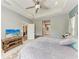 Comfortable main bedroom featuring a tray ceiling, ceiling fan, natural light, and a view of the en-suite bathroom at 1219 Thornbury Dr, Parrish, FL 34219