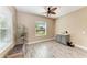 Bright office featuring wood-look tile floors, a ceiling fan, natural light, and a built-in cabinet with stone countertop at 1219 Thornbury Dr, Parrish, FL 34219