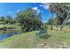 Peaceful view of a park bench overlooking a river, surrounded by lush greenery and trees at 1219 Thornbury Dr, Parrish, FL 34219