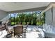 Relaxing screened-in patio with a dining set, swing, and view of the lush backyard at 1219 Thornbury Dr, Parrish, FL 34219