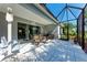 Inviting screened-in patio with dining set, BBQ grill, swing, and access to the lush backyard at 1219 Thornbury Dr, Parrish, FL 34219