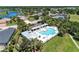 Aerial shot of a community pool with a pergola, sun loungers, and a nearby lake and houses at 1219 Thornbury Dr, Parrish, FL 34219