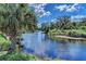 Scenic view of the tranquil river, framed by lush greenery and a vibrant blue sky with scattered clouds at 1219 Thornbury Dr, Parrish, FL 34219