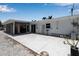Backyard patio area with stucco wall, featuring a ladder, screened in area, and palm trees at 130 N Adams Dr, Sarasota, FL 34236