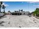 Wide open backyard featuring gravel, palm trees, and an outdoor chair swing at 130 N Adams Dr, Sarasota, FL 34236