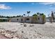 A single story home featuring a rockscape yard and neutral exterior, set against a clear sky and lush landscaping at 130 N Adams Dr, Sarasota, FL 34236