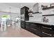Open kitchen featuring dark cabinets, stainless appliances, and an adjacent dining room at 130 N Adams Dr, Sarasota, FL 34236