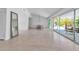 Spacious living area with terrazzo flooring, glass doors, and simple chandelier at 130 N Adams Dr, Sarasota, FL 34236