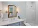 Well-lit bathroom with a marble countertop, stylish mirror, and modern shower with tile accents at 135 Avenida Veneccia, Sarasota, FL 34242