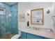 Stylish bathroom featuring blue-tiled shower, marble countertop vanity, and modern fixtures at 135 Avenida Veneccia, Sarasota, FL 34242