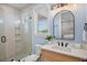 Modern bathroom featuring a glass-enclosed shower, marble countertop, and stylish vanity mirror at 135 Avenida Veneccia, Sarasota, FL 34242