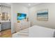 Serene bedroom with a TV, white dresser, and a glimpse into an adjacent bathroom at 135 Avenida Veneccia, Sarasota, FL 34242