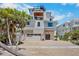 Beautiful three-story home with multiple balconies, a garage, and lush tropical landscaping at 135 Avenida Veneccia, Sarasota, FL 34242