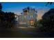 Beautiful three-story home exterior at dusk, featuring a garage and manicured landscaping at 135 Avenida Veneccia, Sarasota, FL 34242